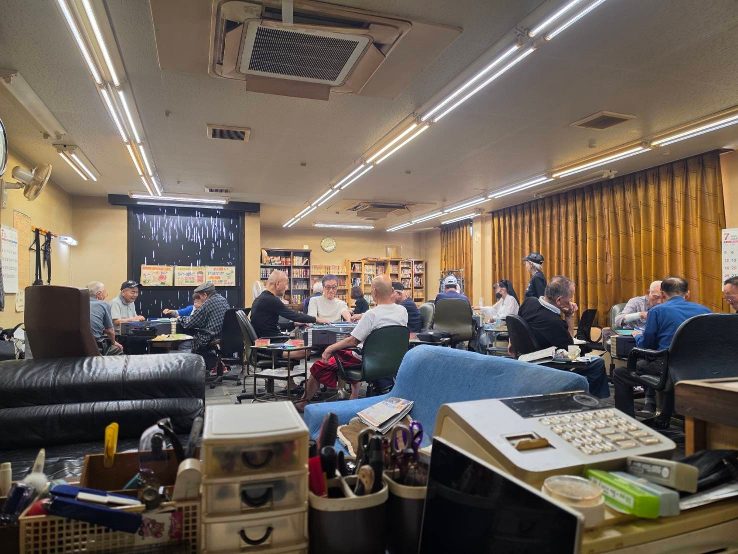 対局前の静かな時間帯に照明が落ち着いて広がる店内の写真